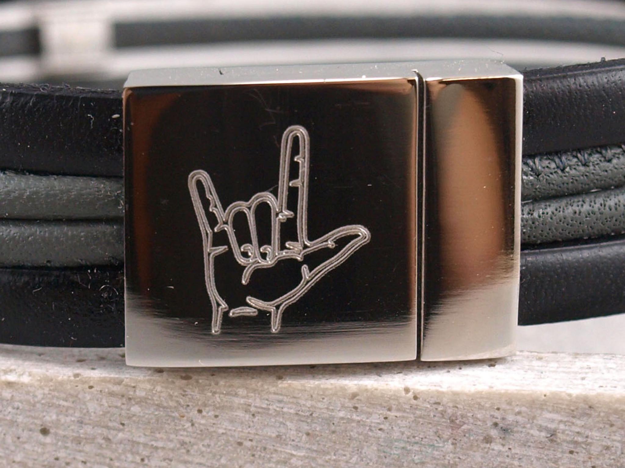 Silberner Magnetverschluss eines Lederarmbandes mit Handzeichen Gebärdensprache als Gravur
