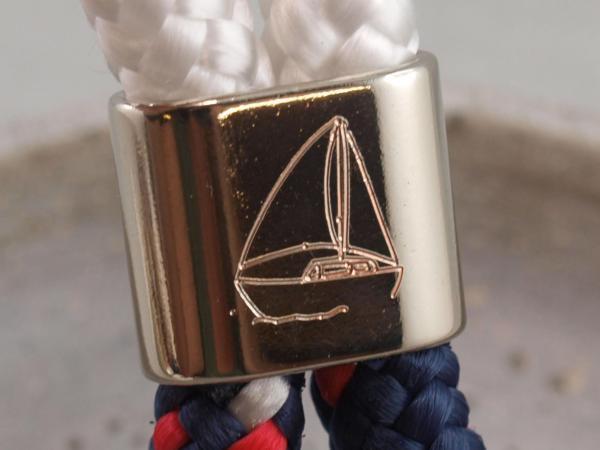 Silberner Slider eines Schluesselanhaengers mit Segelboot Gravur