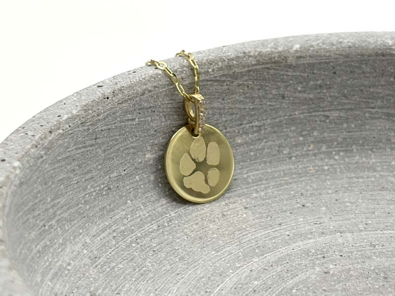 Pfotenabdruck auf einem echt goldenen Gravuranhänger mit Zirkon